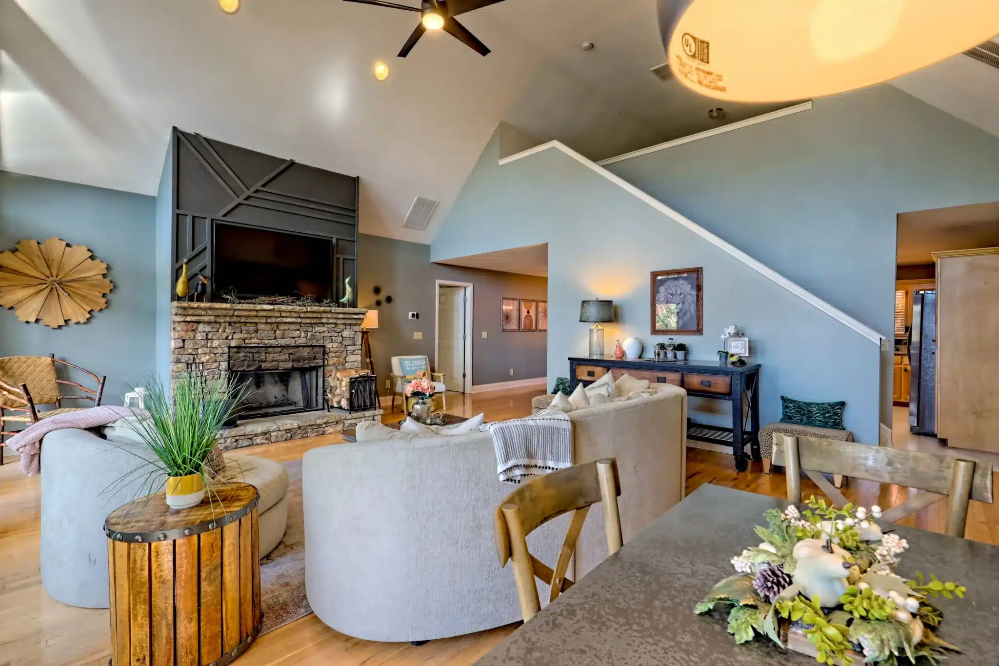 Open-concept living room with vaulted ceilings, stone fireplace, curved sofas in Sunset Ridge, a mountain lake chalet rental
