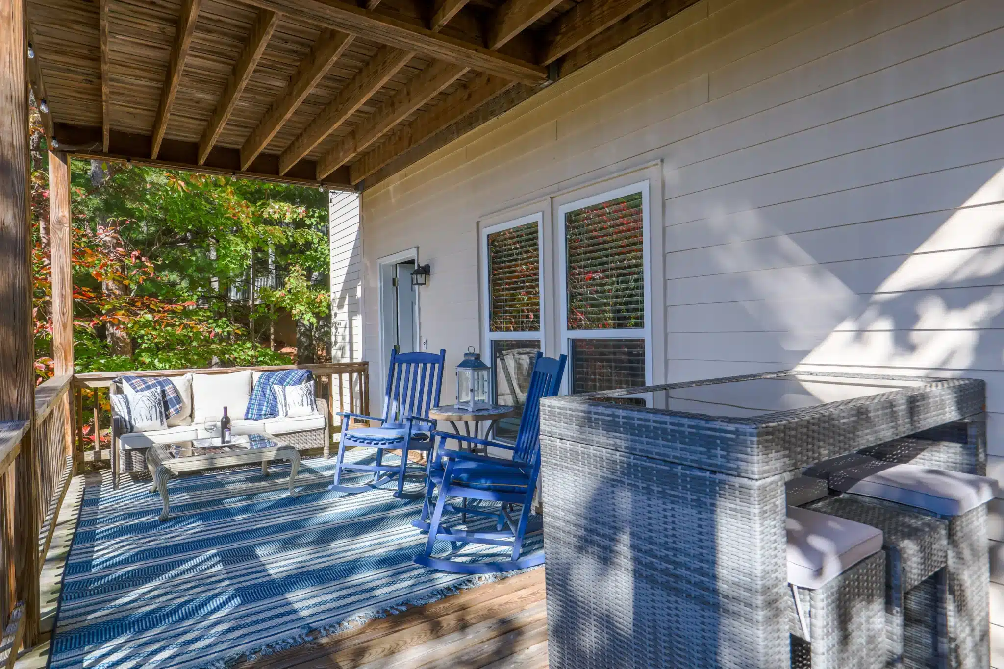 Covered deck with rocking chairs at Sunset Ridge, a Clayton GA chalet to unwind after Clayton festivals